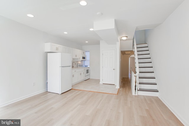 unfurnished living room featuring sink and light wood-type flooring