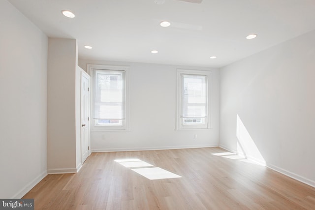 spare room featuring a healthy amount of sunlight and light hardwood / wood-style floors