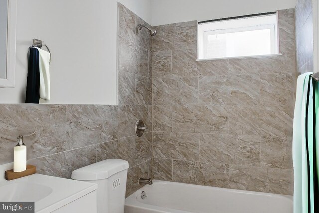 full bathroom with vanity, toilet, and tiled shower / bath combo