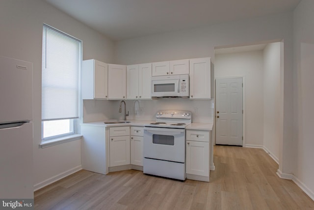 kitchen with light hardwood / wood-style flooring, sink, white appliances, and white cabinets