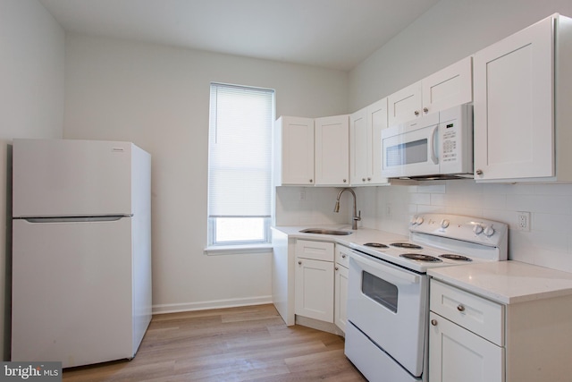 kitchen featuring backsplash, light hardwood / wood-style flooring, white appliances, white cabinetry, and sink