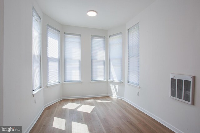 spare room featuring light wood-type flooring and heating unit