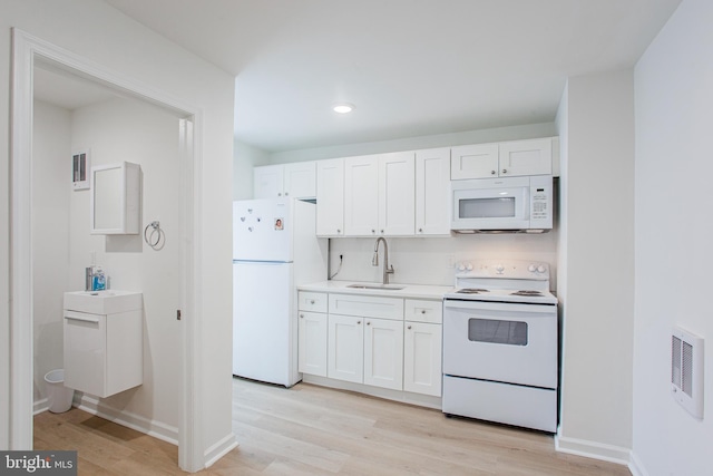 kitchen featuring light wood-type flooring, sink, white appliances, and white cabinetry