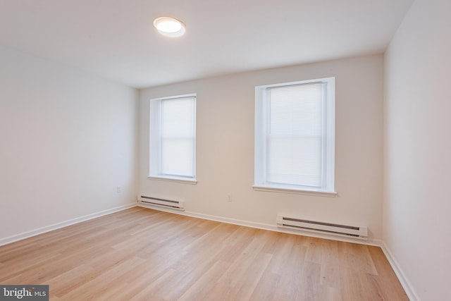 unfurnished room with light wood-type flooring and a baseboard radiator