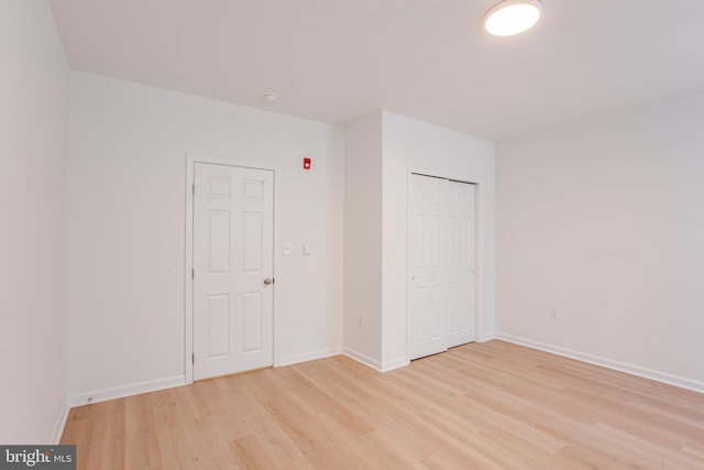 unfurnished bedroom featuring a closet and light hardwood / wood-style floors