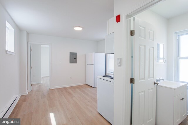 kitchen featuring white appliances, a healthy amount of sunlight, white cabinets, and light hardwood / wood-style floors