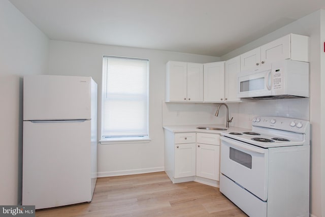 kitchen with white appliances, backsplash, light hardwood / wood-style floors, sink, and white cabinets