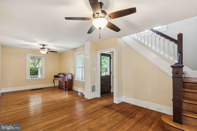 interior space featuring a healthy amount of sunlight, ceiling fan, and dark hardwood / wood-style floors