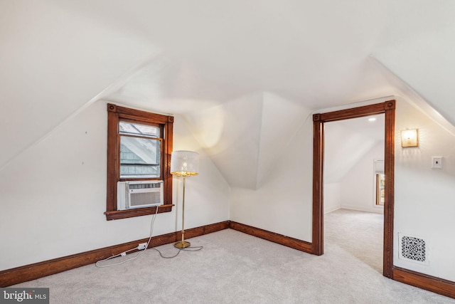 additional living space featuring vaulted ceiling and light colored carpet