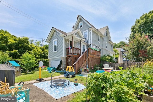 back of property featuring a fire pit, a patio area, a deck, and a lawn