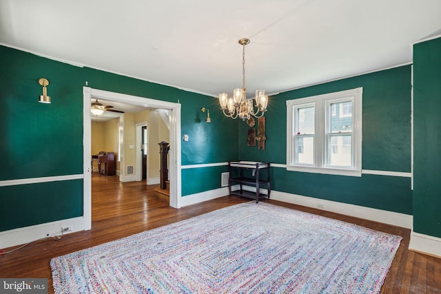 dining area featuring dark hardwood / wood-style floors and ceiling fan with notable chandelier