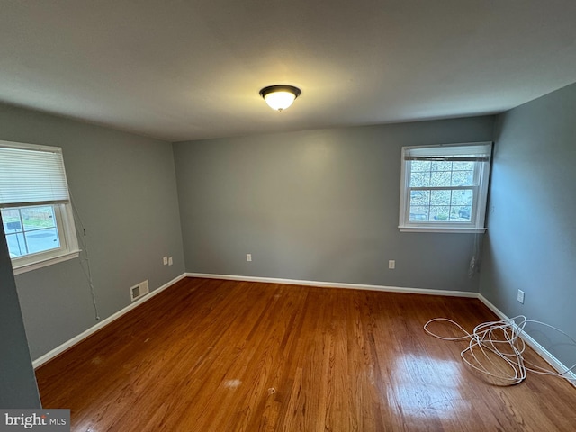 unfurnished room with a healthy amount of sunlight and wood-type flooring