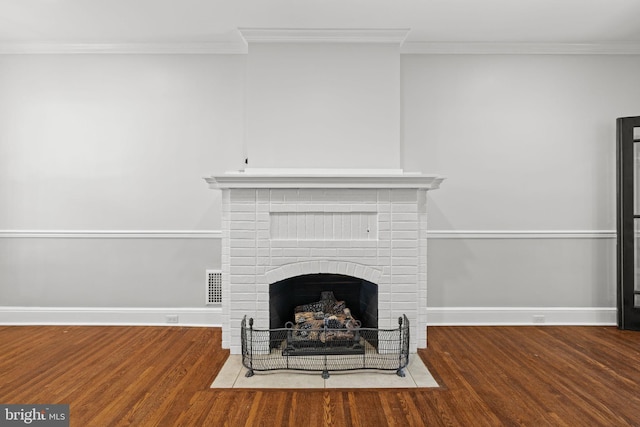 details featuring wood-type flooring, crown molding, and a fireplace