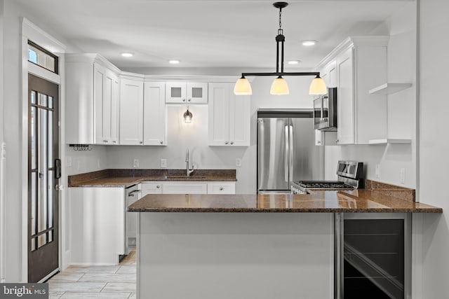 kitchen featuring white cabinetry, kitchen peninsula, and appliances with stainless steel finishes