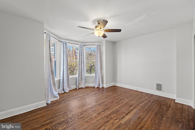 empty room with dark wood-type flooring and ceiling fan