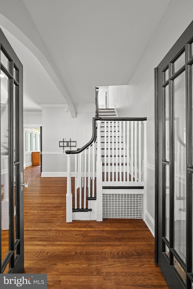 stairway featuring beamed ceiling and hardwood / wood-style flooring