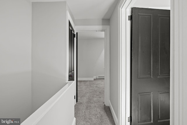 corridor featuring baseboard heating and light carpet