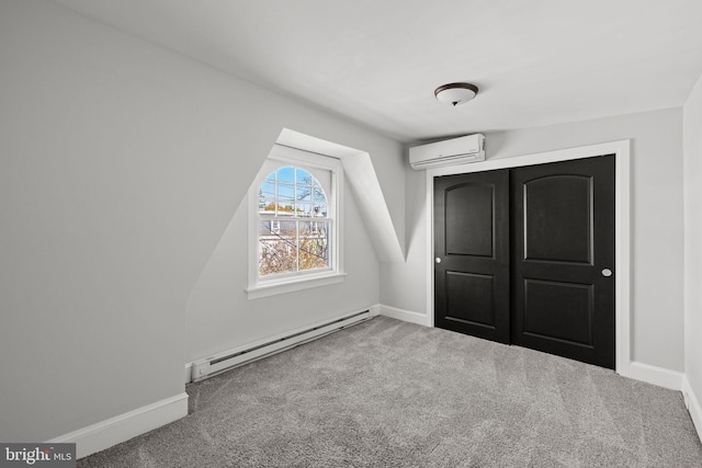 unfurnished bedroom featuring carpet flooring, a closet, a baseboard radiator, and a wall mounted air conditioner