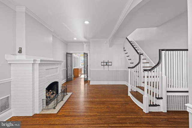 interior space featuring a fireplace, dark hardwood / wood-style floors, and ornamental molding