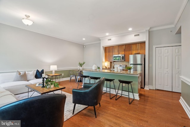 living room with light wood-type flooring and ornamental molding