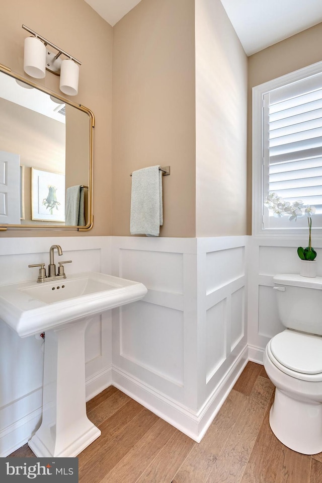 bathroom with toilet, hardwood / wood-style flooring, and sink