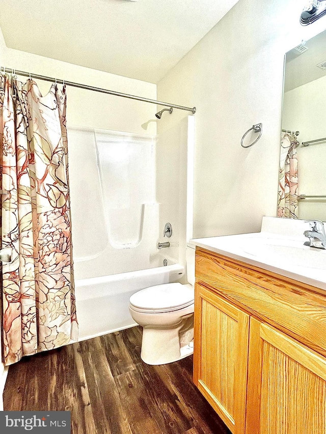 full bathroom with shower / tub combo, hardwood / wood-style flooring, vanity, and toilet