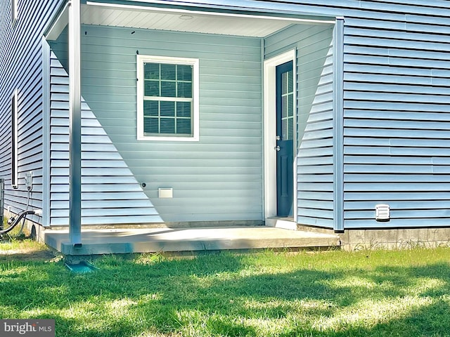 property entrance featuring a lawn