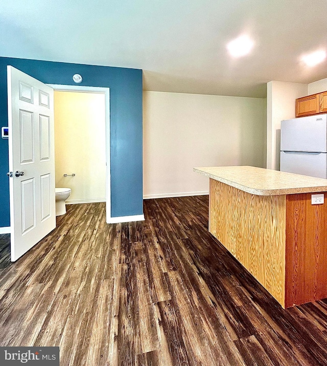 kitchen with white refrigerator and dark hardwood / wood-style flooring