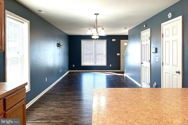 interior space featuring an inviting chandelier and dark hardwood / wood-style flooring