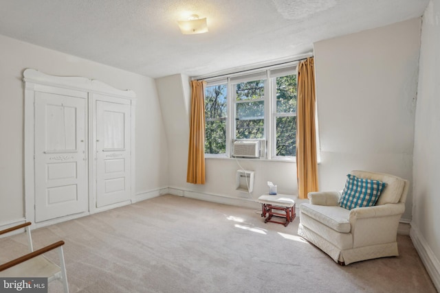 sitting room with a textured ceiling, cooling unit, and light carpet