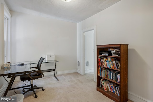 office with light colored carpet and a textured ceiling