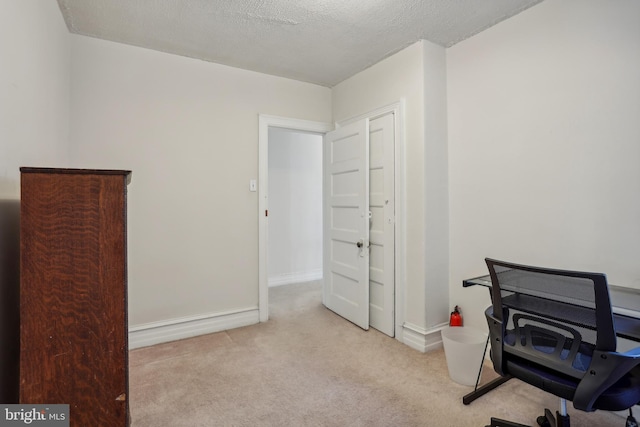 home office with a textured ceiling and light colored carpet