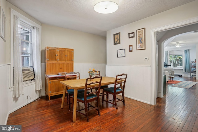 dining area with a textured ceiling, cooling unit, dark hardwood / wood-style floors, and ceiling fan