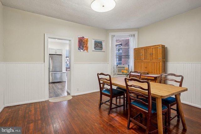 dining area with a textured ceiling and dark hardwood / wood-style flooring