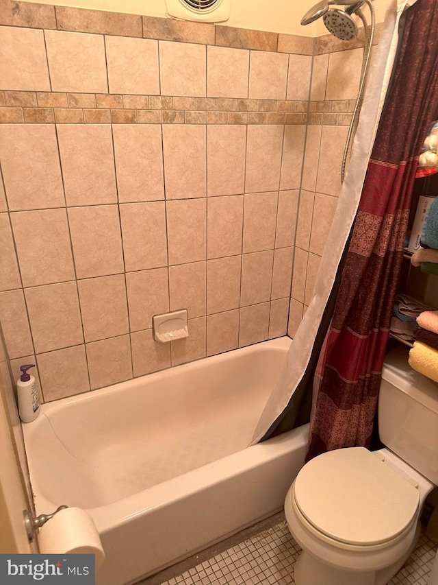 bathroom with toilet, shower / tub combo, and tile patterned flooring