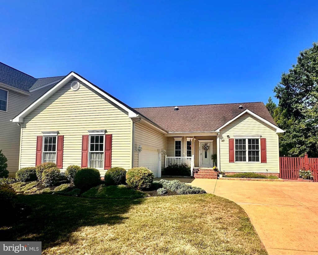 ranch-style house featuring a garage and a front lawn