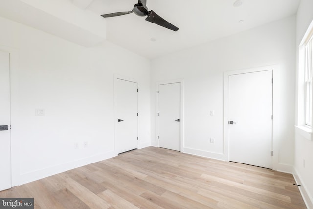 interior space featuring light wood-type flooring, multiple closets, and ceiling fan