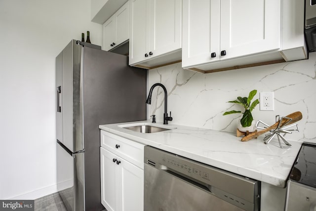 kitchen with white cabinets, appliances with stainless steel finishes, and backsplash