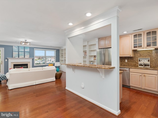 kitchen featuring light stone countertops, sink, a kitchen breakfast bar, tasteful backsplash, and appliances with stainless steel finishes