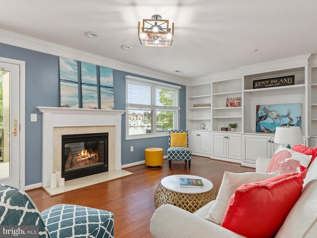 living room with hardwood / wood-style floors, a premium fireplace, and crown molding