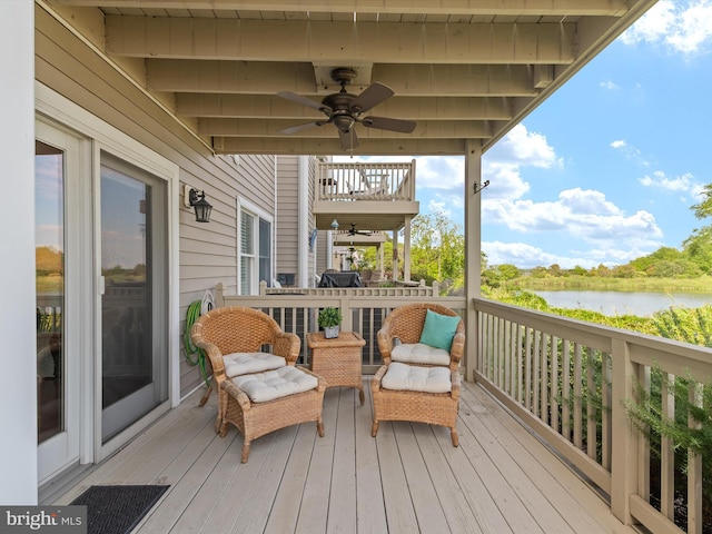 deck featuring ceiling fan and a water view