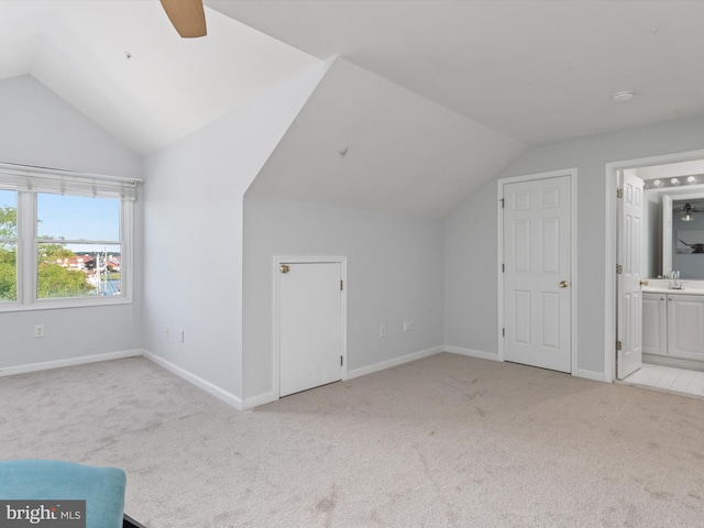 bonus room with light carpet, vaulted ceiling, ceiling fan, and sink