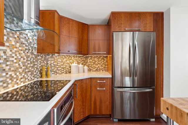 kitchen featuring decorative backsplash, appliances with stainless steel finishes, brown cabinetry, and light countertops