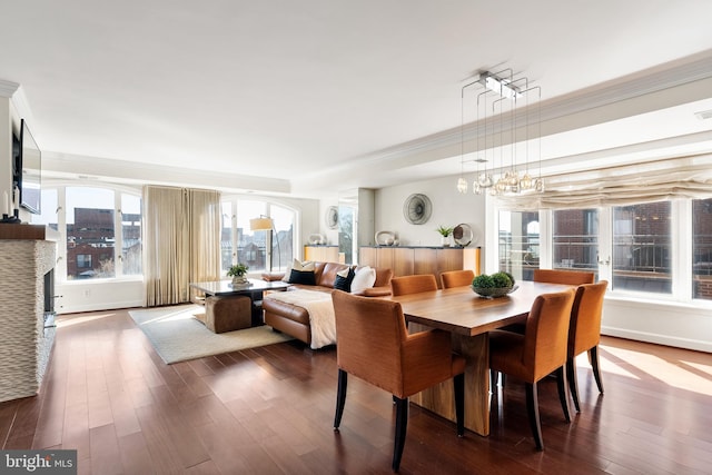 dining space with dark wood-style floors and crown molding