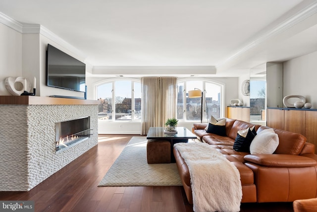 living room featuring a fireplace, dark wood-style flooring, and crown molding