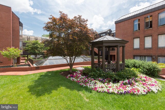 exterior space featuring a gazebo, a lawn, and fence