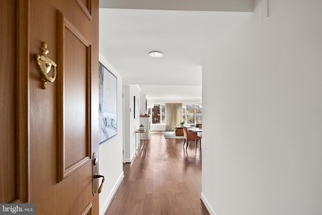 hallway with baseboards and wood finished floors