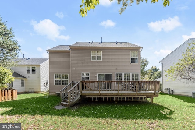 rear view of house featuring a deck and a yard