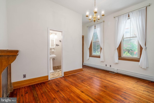 unfurnished dining area with wood-type flooring, a baseboard radiator, and an inviting chandelier