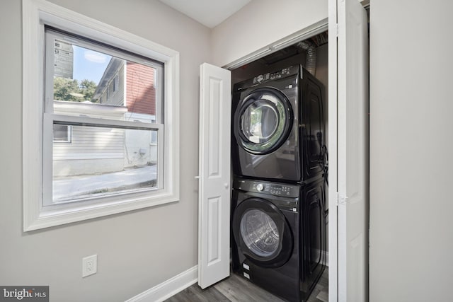 washroom with wood-type flooring and stacked washer and dryer